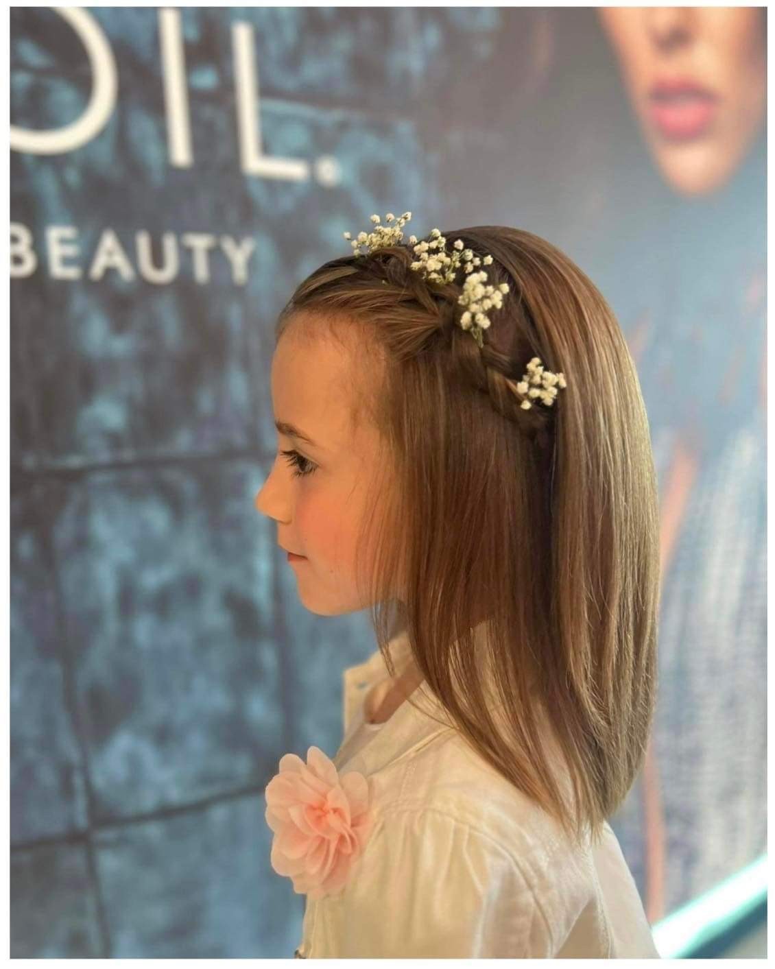 Communicantje stijl haar gevlochten bloemen bovenaan het kapsel