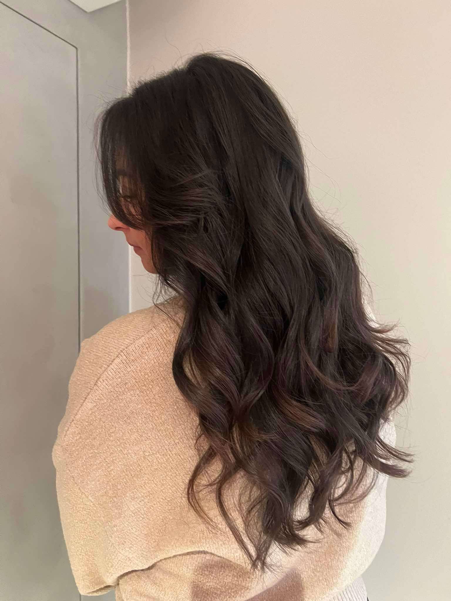 Dame met donker gekleurd lang krullend haar.