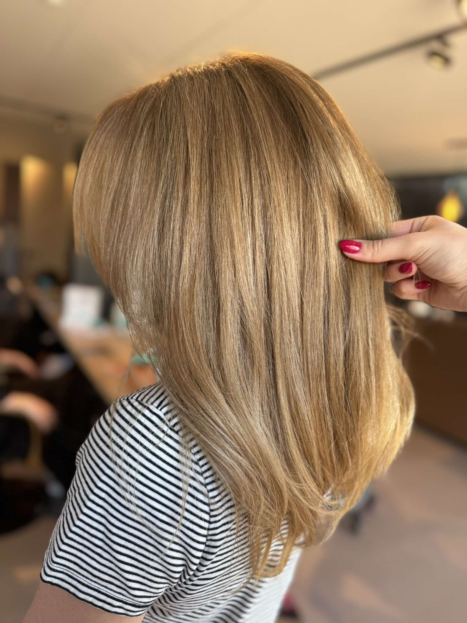 Dame met lichtbruin gekleurd halflang stijl haar.