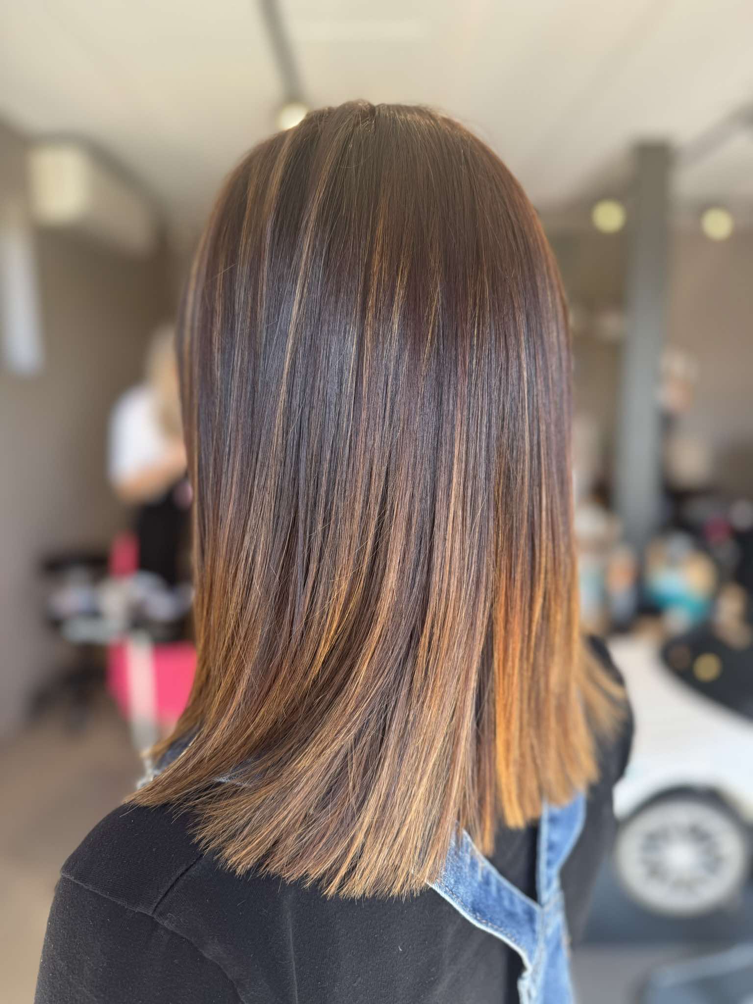 Dame met donker gekleurd halflang stijl haar met lichte toppen.